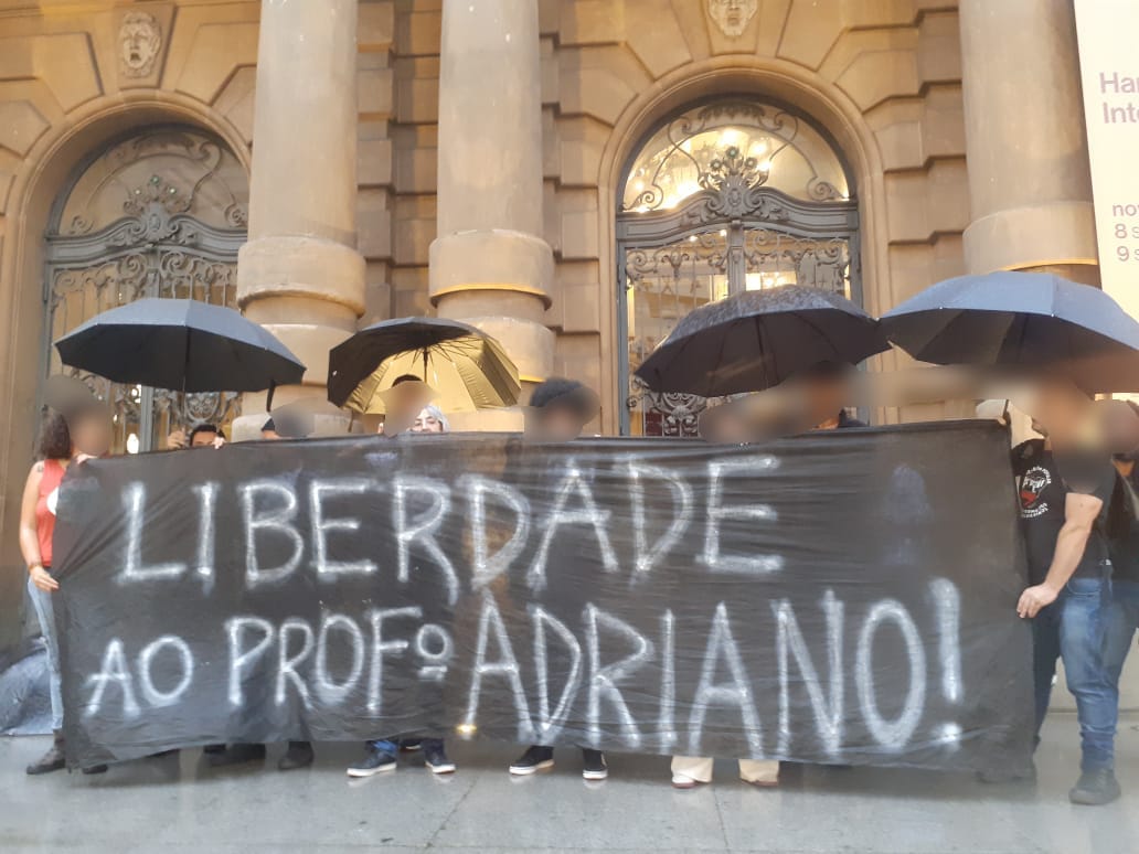 Sob a chuva e o olhar sanguinário da polícia, manifestantes exigem a liberdade do professor Adriano Gomes da Silva